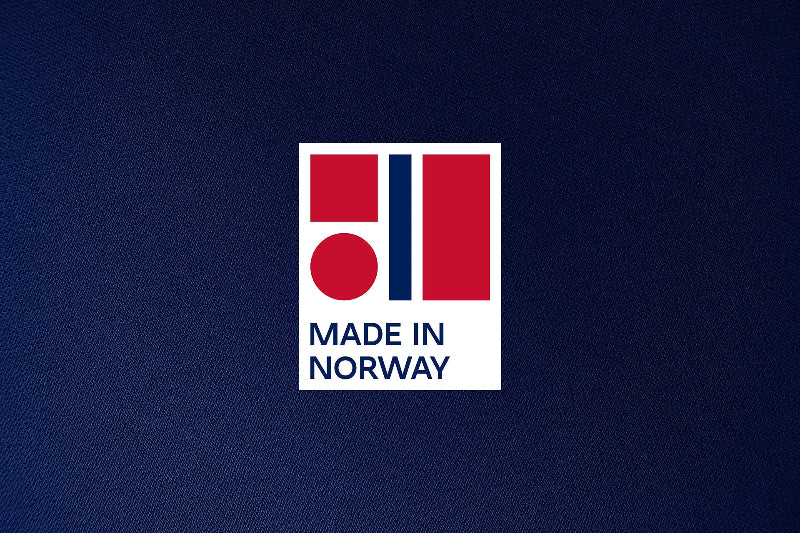 Lacivert kumaş zemin üzerinde, kırmızı ve lacivert renklerden oluşan 'Made in Norway' (Norveç üretimi) logosu.