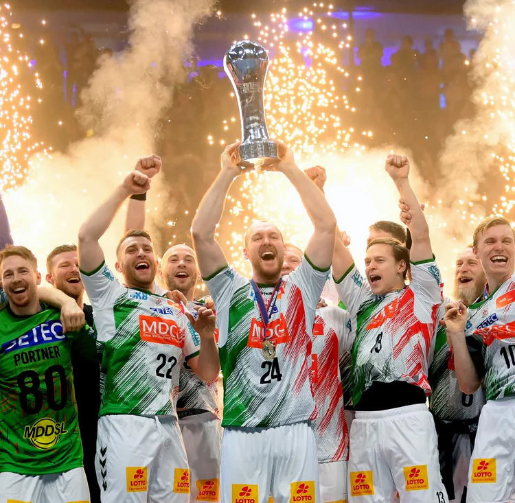 SC Magdeburg hentbol takımı şampiyonluk kupasını kaldırırken kutlama yapıyor — Avrupa hentbolunun zirvesinde başarı, takım ruhu ve sportif mükemmellik vurgusu yapılıyor