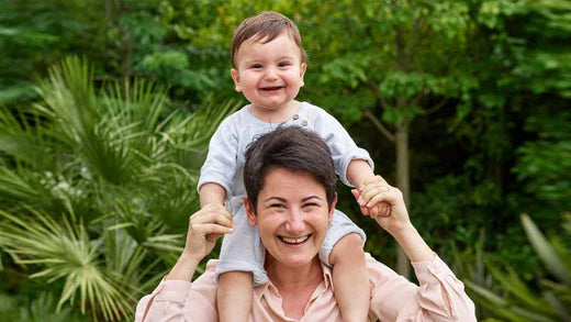 Doğada gülümseyen anne ve bebek – Ballstad omega-3 ile desteklenen sağlıklı yaşam, enerji ve mutluluğu temsil eden doğal bir an.