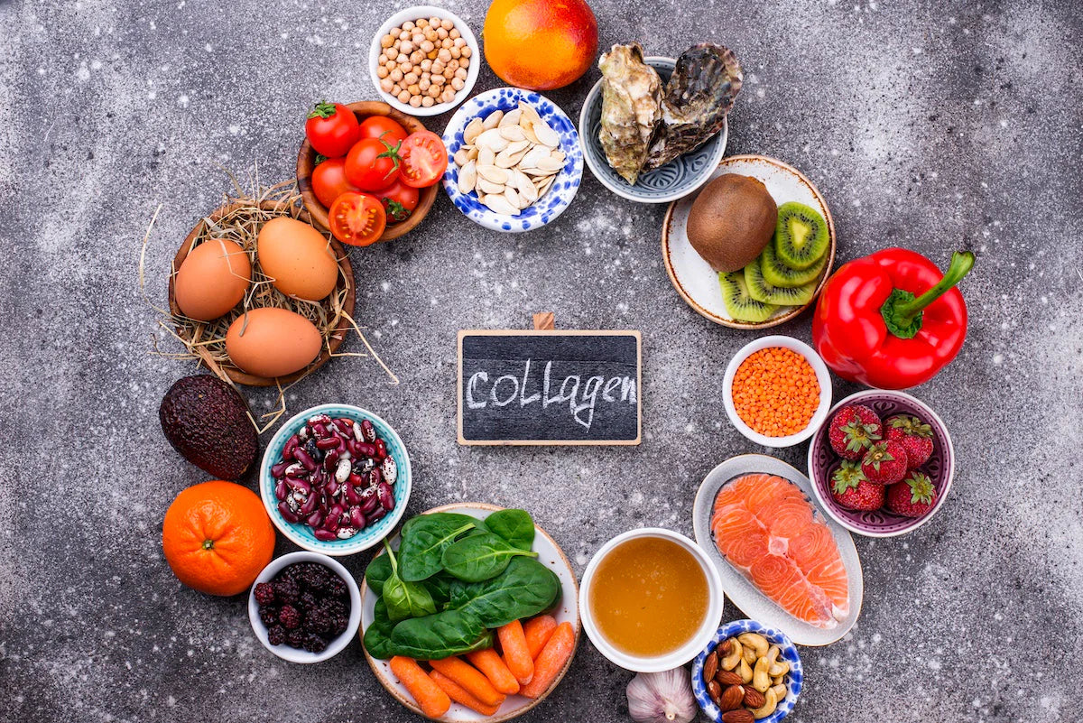 Yumurta, somon, kırmızı biber, kivi, ıspanak, kuruyemiş ve mercimek gibi kolajen üretimini destekleyen gıdaların çevresinde ‘collagen’ yazılı küçük bir tahta tabelayla düzenlenmiş üstten görünüm.