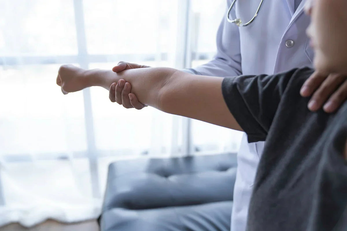 Doktor, hastanın kolunu nazikçe hareket ettirerek eklem esnekliğini ve hareket kabiliyetini inceliyor.